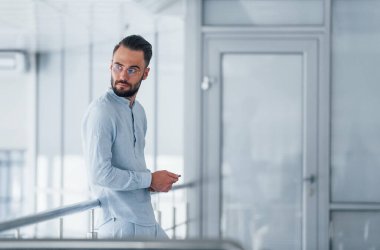 Gündüz vakti ofiste resmi kıyafetler içinde genç yakışıklı bir adam..