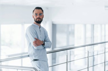 Gündüz vakti ofiste resmi kıyafetler içinde genç yakışıklı bir adam..