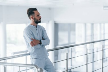 Gündüz vakti ofiste resmi kıyafetler içinde genç yakışıklı bir adam..