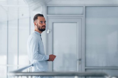 Gündüz vakti ofiste resmi kıyafetler içinde genç yakışıklı bir adam..