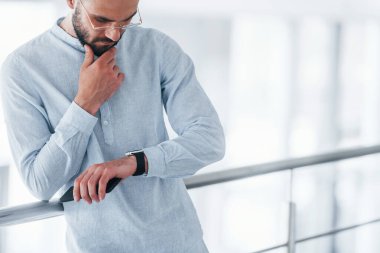 Gündüz vakti ofiste resmi kıyafetler içinde genç yakışıklı bir adam..