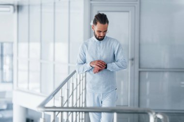 Gündüz vakti ofiste resmi kıyafetler içinde genç yakışıklı bir adam..