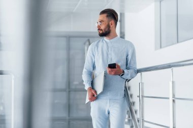 Telefonla. Gündüz vakti ofiste resmi kıyafetler içinde genç yakışıklı bir adam..