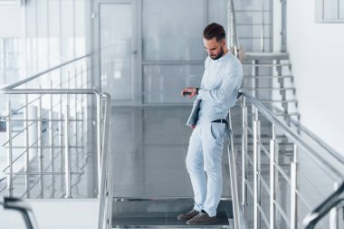 Telefonla. Gündüz vakti ofiste resmi kıyafetler içinde genç yakışıklı bir adam..