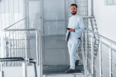 Telefonla. Gündüz vakti ofiste resmi kıyafetler içinde genç yakışıklı bir adam..