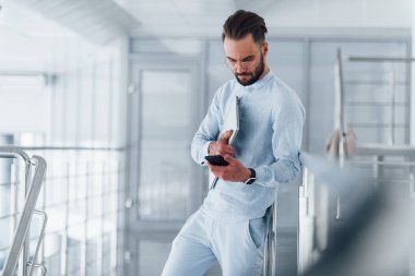 Telefonla. Gündüz vakti ofiste resmi kıyafetler içinde genç yakışıklı bir adam..