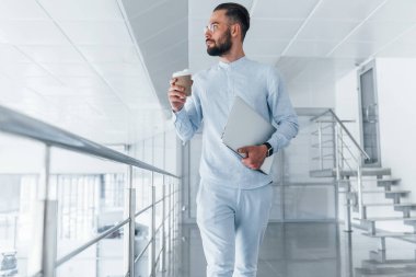 Bardağı içkiyle birlikte tutuyorum. Gündüz vakti ofiste resmi kıyafetler içinde genç yakışıklı bir adam..