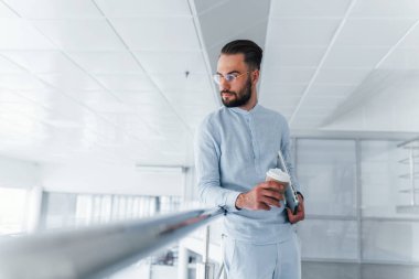 Bardağı içkiyle birlikte tutuyorum. Gündüz vakti ofiste resmi kıyafetler içinde genç yakışıklı bir adam..