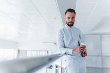 Bardağı içkiyle birlikte tutuyorum. Gündüz vakti ofiste resmi kıyafetler içinde genç yakışıklı bir adam..