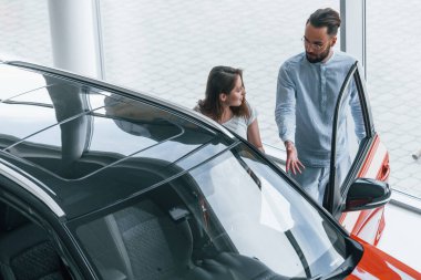 Olumlu genç kız otosalon 'u ziyaret ediyor ve araba seçiyor. Müdür ona yardım ediyor..