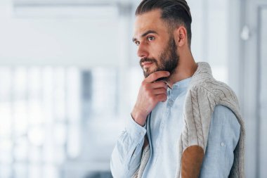 Gündüz vakti ofiste resmi kıyafetler içinde genç yakışıklı bir adam..