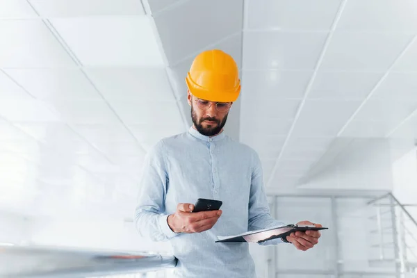 Telefon Ingenieur Weißer Kleidung Und Orangefarbenem Schutzhelm Steht Und Arbeitet — Stockfoto