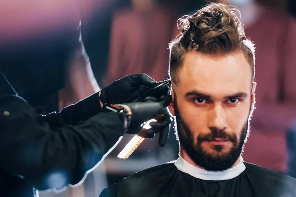 Jovem Barbudo Sentado Recebendo Corte Cabelo Barbearia — Fotografia de Stock