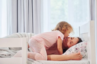 Uyku vakti. Genç bir anne ve küçük kızı evde birlikte günlük kıyafetler giyiyorlar..