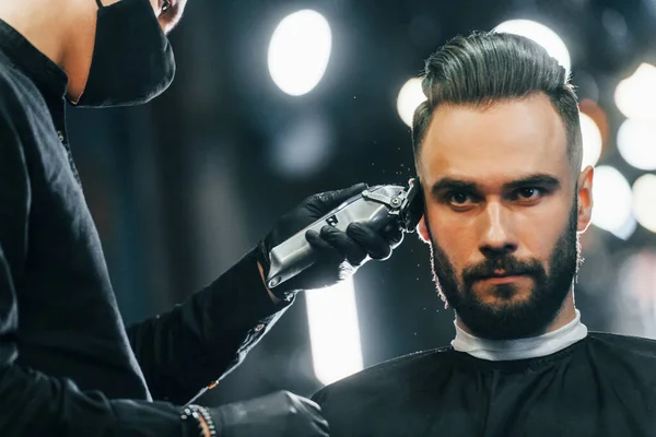 Jovem Com Penteado Elegante Sentado Recebendo Sua Barba Raspada Barbearia — Fotografia de Stock