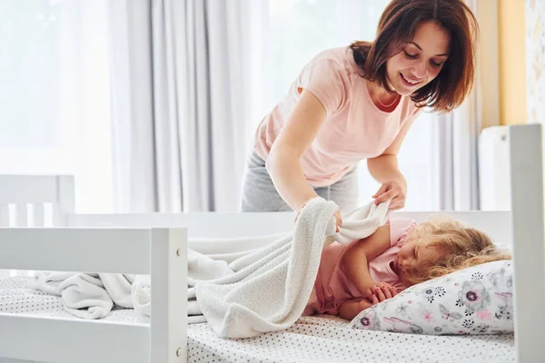 Uyku vakti. Genç bir anne ve küçük kızı evde birlikte günlük kıyafetler giyiyorlar..