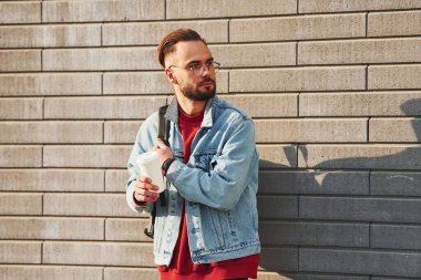 Günlük kıyafetlerle yakışıklı genç adam güneşli bir günde dışarıda..