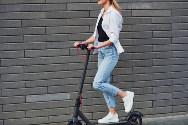 Gündüz vakti açık havada elektrikli sandalla gezen günlük kıyafetli güzel bir sarışın..