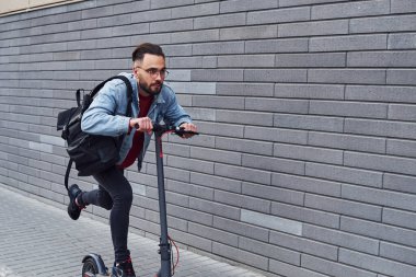 Gündüz vakti açık havada elektrikli sandalla gezen sıradan giysili yakışıklı bir genç..