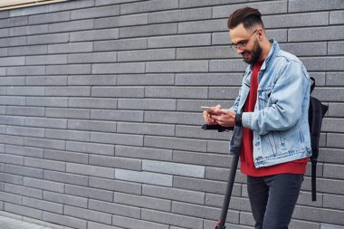 Gündüz vakti açık havada elektrikli sandalla gezen sıradan giysili yakışıklı bir genç..