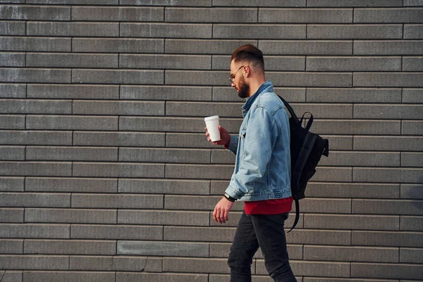 Günlük kıyafetlerle yakışıklı genç adam güneşli bir günde dışarıda..