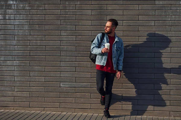 Günlük kıyafetlerle yakışıklı genç adam güneşli bir günde dışarıda..