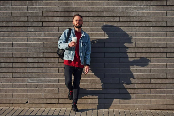 Günlük kıyafetlerle yakışıklı genç adam güneşli bir günde dışarıda..