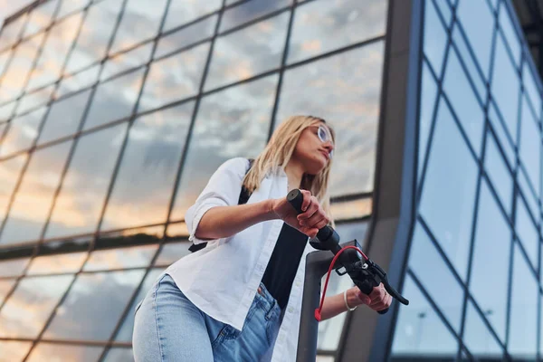 Modern Business Building Beautiful Blonde Casual Clothes Riding Electric Schooter —  Fotos de Stock