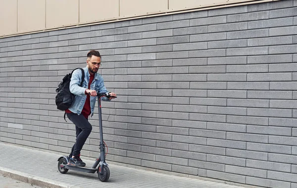 Gündüz vakti açık havada elektrikli sandalla gezen sıradan giysili yakışıklı bir genç..