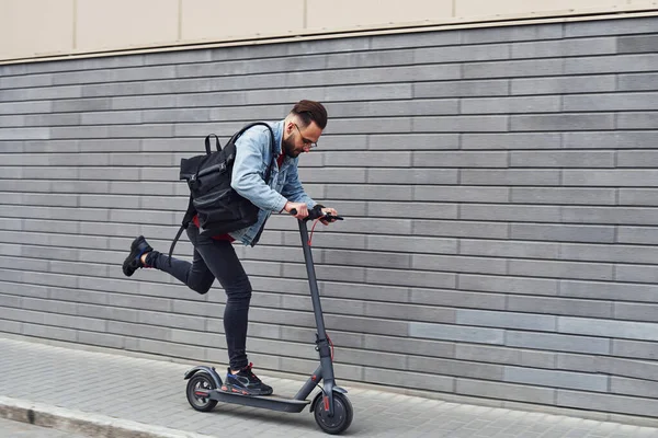 Gündüz vakti açık havada elektrikli sandalla gezen sıradan giysili yakışıklı bir genç..
