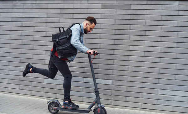 Gündüz vakti açık havada elektrikli sandalla gezen sıradan giysili yakışıklı bir genç..
