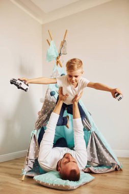 Çocuk ellerde. Babası ve genç kızı çadırın yanında birlikte vakit geçiriyorlar..