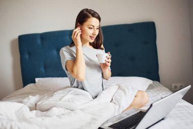 Laptop kullanıyorum. Genç bayan dinleniyor ve hafta sonunu evde yalnız geçiriyor..