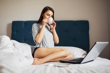 Laptop kullanıyorum. Genç bayan dinleniyor ve hafta sonunu evde yalnız geçiriyor..