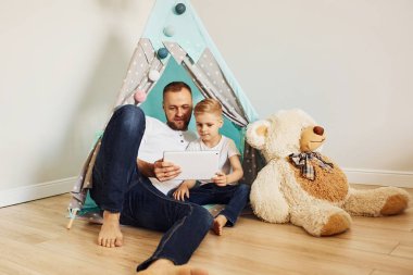 Baba ve yavruları çadırın yanında oturup birlikte vakit geçiriyorlar..