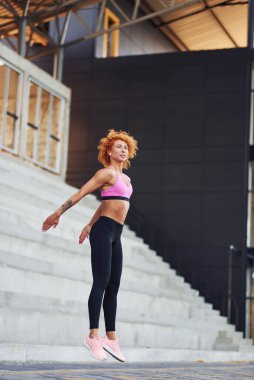 Avrupalı genç, kızıl saçlı, açık havada spor elbiseli bir kadın..