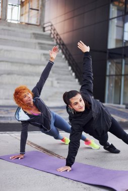 Şınav çekiyorum. Spor vücutlu iki bayan arkadaşın dışarıda spor günü var..