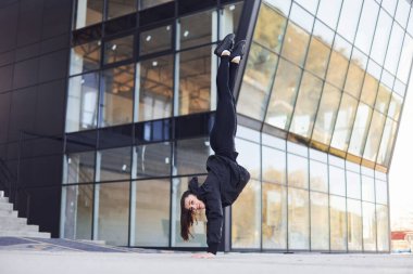 Çılgınca numaralar yapıyor. Spor elbiseli genç esmer şehirde spor günü düzenliyor..