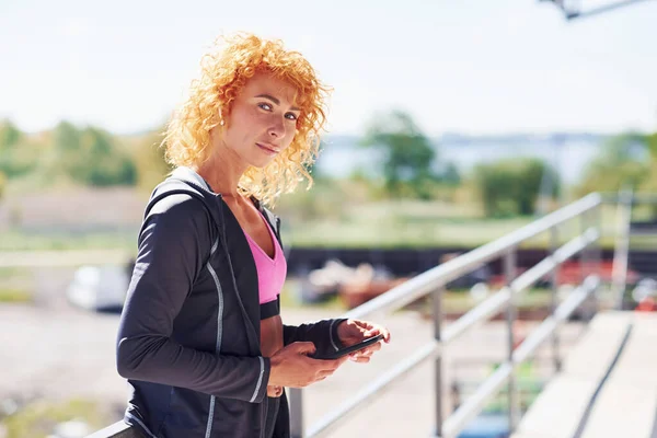 Avrupalı Genç Kızıl Saçlı Spor Elbiseli Açık Havada Elinde Telefonla — Stok fotoğraf