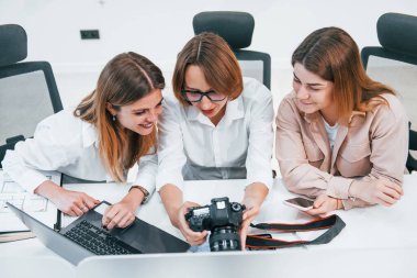 Ofiste çalışan bir grup resmi giyinmiş iş adamının önünde..