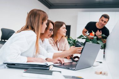 Ofiste çalışan bir grup resmi giyinmiş iş adamının önünde..