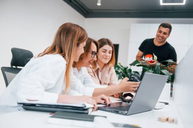 Ofiste çalışan bir grup resmi giyinmiş iş adamının önünde..