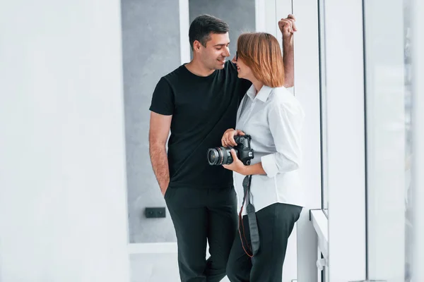 身着正式服装 手持相机的女人与男人站在空房间里 — 图库照片