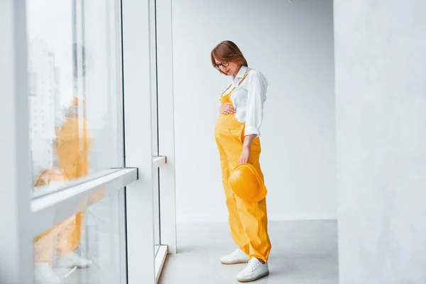 Vrouwelijke Werknemer Ingenieur Geel Uniform Harde Hoed Die Binnen Staat — Stockfoto