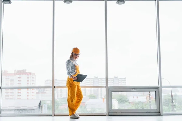 Big Window Female Worker Engineer Yellow Uniform Hard Hat Standing — Stock Photo, Image