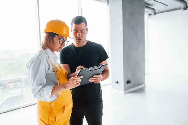 Trabajadora Ingeniera Uniforme Amarillo Sombrero Duro Pie Interior Con Hombre — Foto de Stock