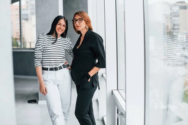 Twee Zakenvrouwen Staan Samen Binnen Het Kantoor Bij Een Groot — Stockfoto