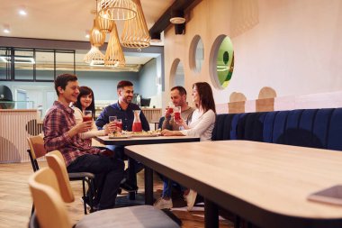 Evde oturup pizza yiyen bir grup genç arkadaş..