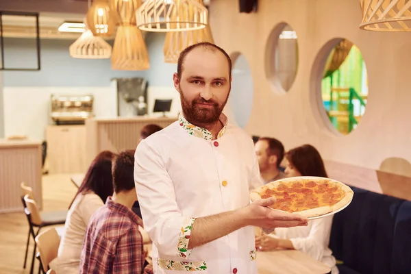 Chef Staan Met Pizza Handen Tegen Een Groep Jonge Vrienden — Stockfoto