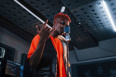 Ses alıştırması yapıyorum. Genç Afrikalı Amerikalı sanatçı bir kayıt stüdyosunda prova yapıyor..